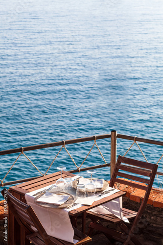 Obraz na plátne Wooden table with white, dishwater and chairs on ocean in a rest