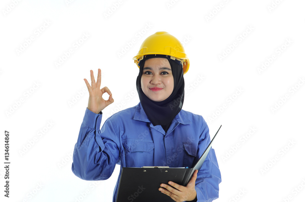 Construction worker wear yellow safety helmet show okay sign while holding a file Construction worker wear yellow safety helmet show okay sign while holding a file