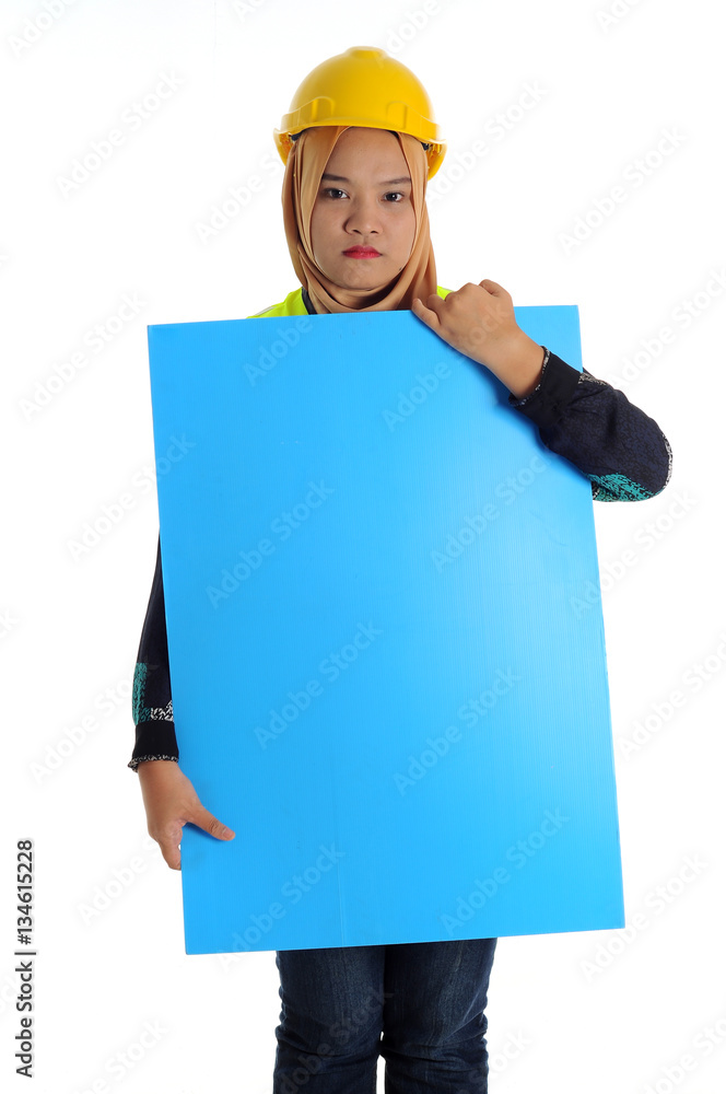 Construction worker wear yellow safety helmet look front in serious mode while holding text space card. Construction worker wear yellow safety helmet look front in serious mode while holding text space card.