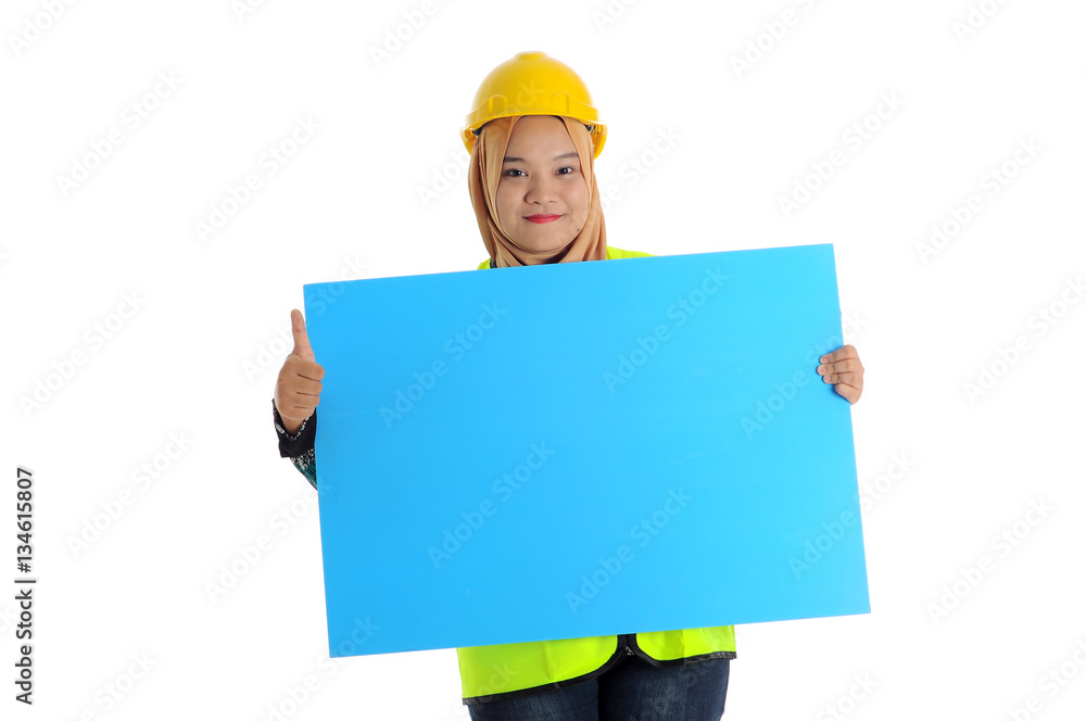 Construction worker wear yellow safety helmet show thumbs up and smile while holding text space card. Construction worker wear yellow safety helmet show thumbs up and smile while holding text space card.