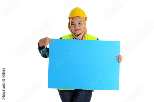 Construction worker wear yellow safety helmet look front and smile while holding text space card.