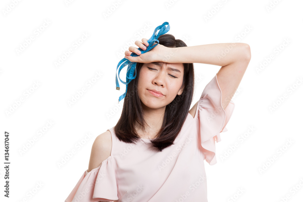 Unhappy young Asian business woman with measuring tape. Unhappy young Asian business woman with measuring tape.