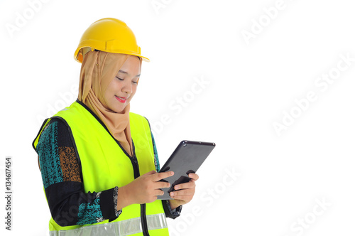 Construction worker wear yellow safety helmet smile while looking a tablet