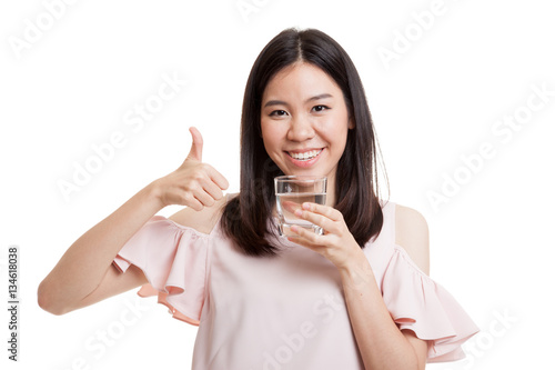 Young Asian woman thumbs up with a glass of drinking water.