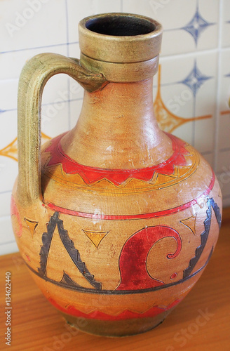 Ancient jug isolated from white wall