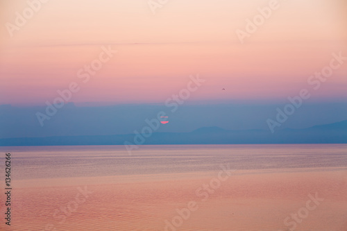 sunrise falling behind mountains on greek island