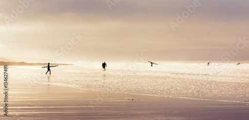 Surfers enjoying the waves on a winters day at Rest Bay in Wales, United Kingdom. photo