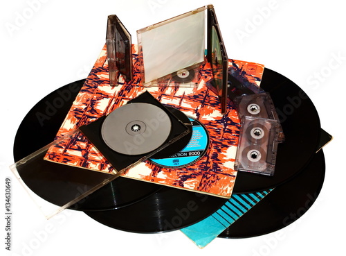 pile old vinyl records in a paper case, tape cassette and cd disk on white background
