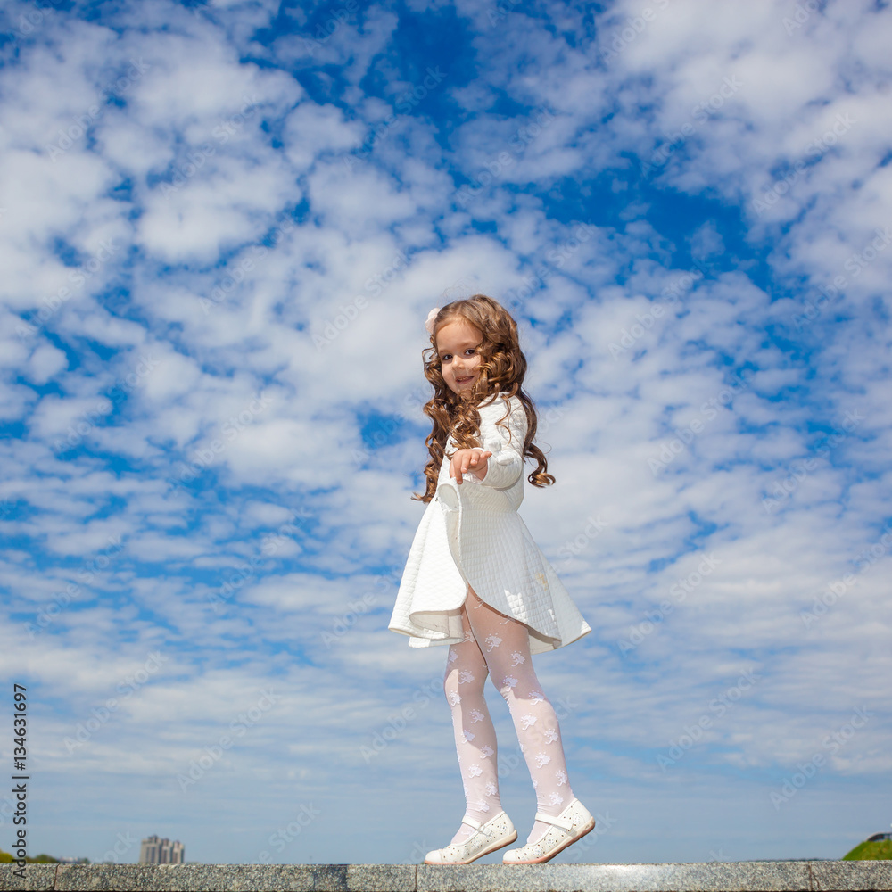 Fototapeta premium little girl in the clouds. little girl walks among the clouds. dreamy and fantasy concept