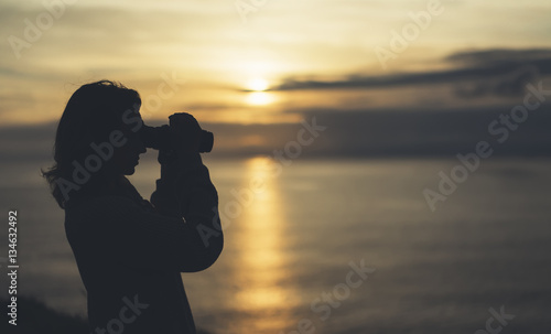 Clouds sunlight sunset on horizon ocean. Silhouette person tourist traveler photographer making pictures seascape on vintage photo camera on background sunrise.mockup evening nature