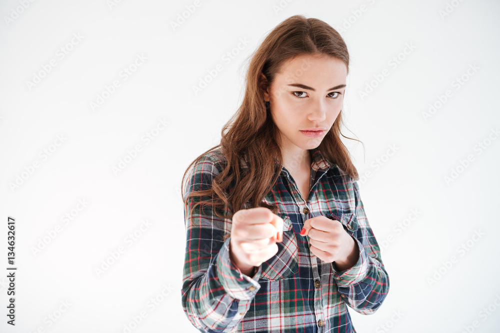 Angry concentrated young woman with fists ready to fight Angry concentrated young woman with fists ready to fight