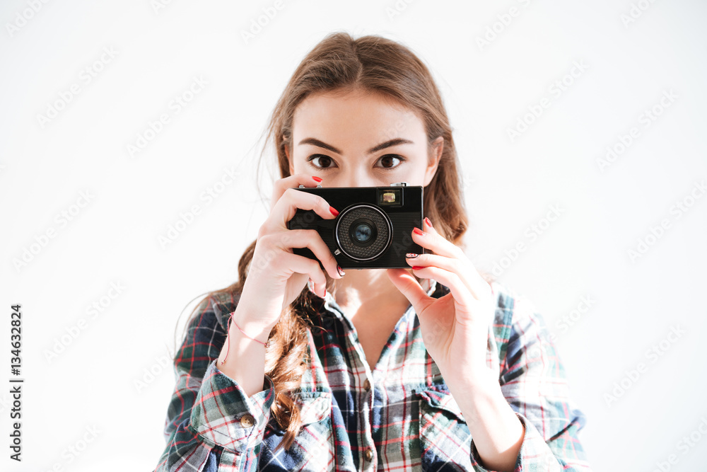 Woman holding camera over white background Woman holding camera over white background