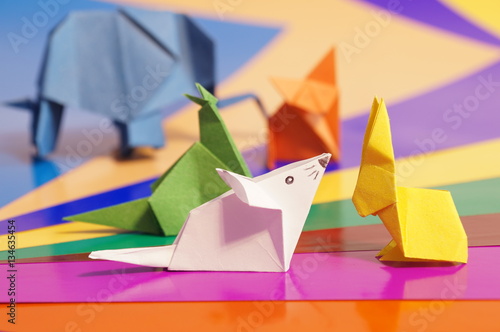 Paper origami animals isolated on a colorful background © romanklevets