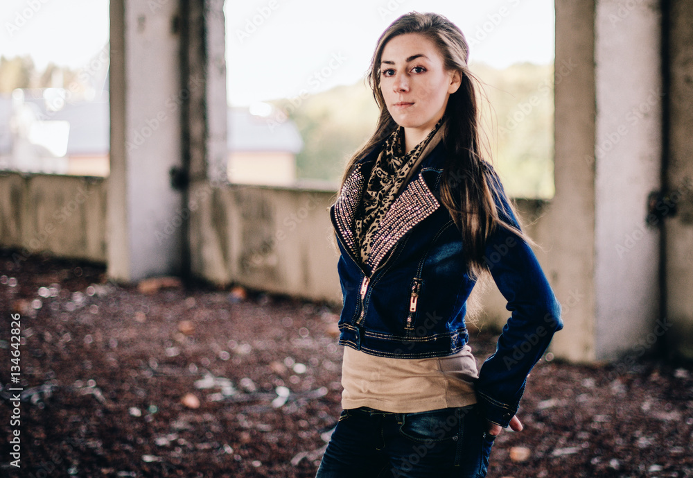 Portrait of young girl wearing jeans jacket on abadoned place.