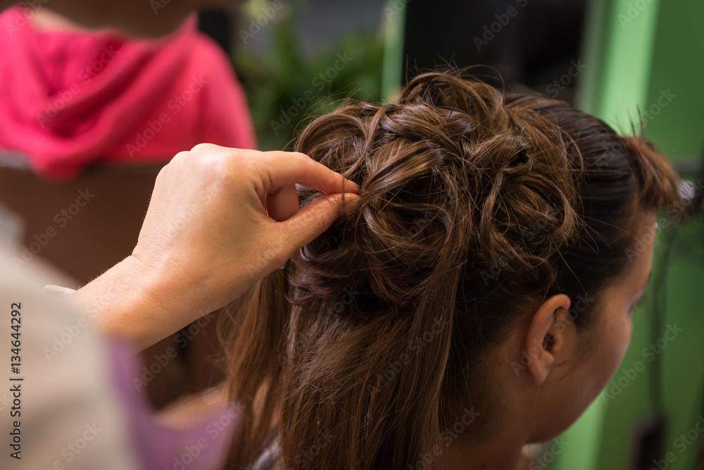 Obraz premium Preparazione acconciatura da sposa con capelli lunghi castani 