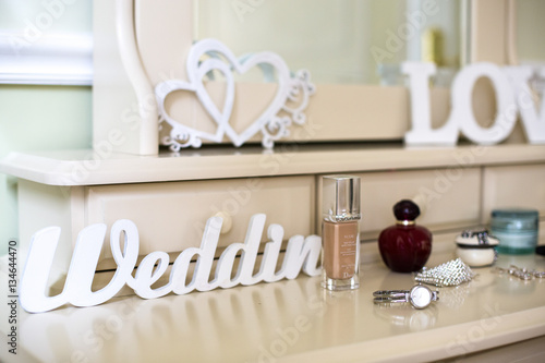 White lettering 'Wedding' stands before woman's accessories on t