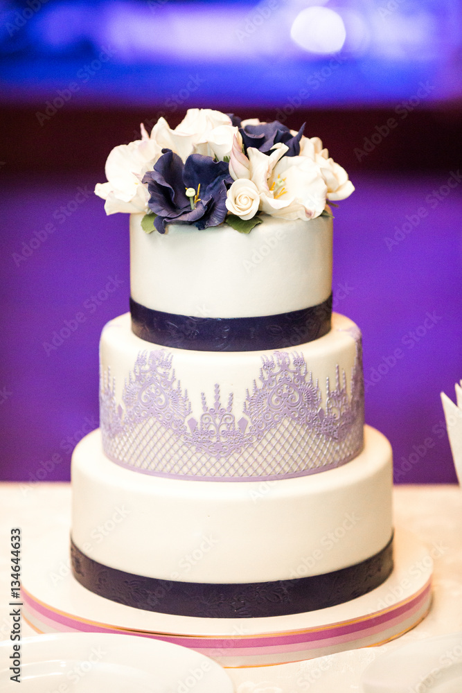Beautiful wedding cake decorated with white and violet flowers a Beautiful wedding cake decorated with white and violet flowers a
