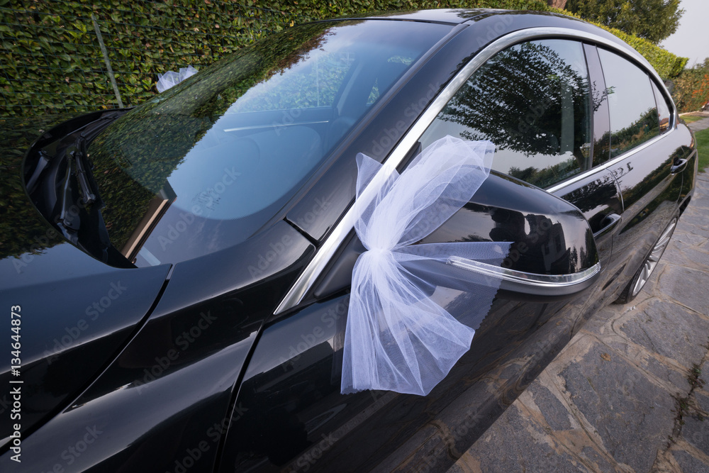 Foto Stock Fiocco di tulle bianco agganciato allo specchietto della  macchina degli sposi | Adobe Stock