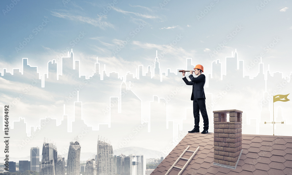 Engineer man standing on roof and looking in spyglass. Mixed med Engineer man standing on roof and looking in spyglass. Mixed med