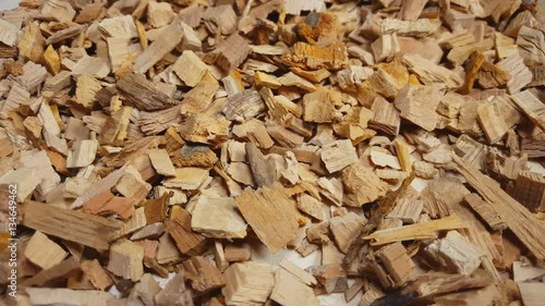 Wood chips for smoking or recycle rotate on the table. Macro shot.