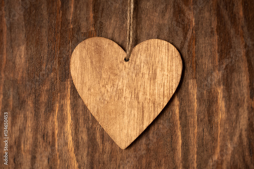 One Wooden Brown Heart With Rope On Wooden Background Close Up.