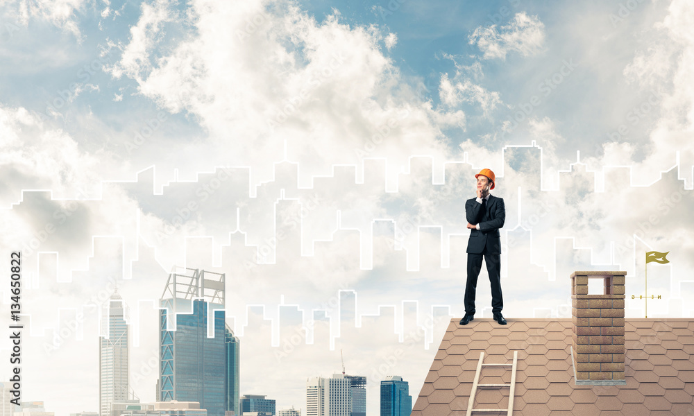 Engineer man standing on roof and looking away. Mixed media Engineer man standing on roof and looking away. Mixed media