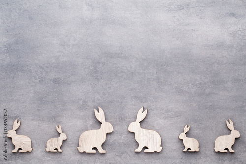 Handmade wood easter rabbits on wooden background.