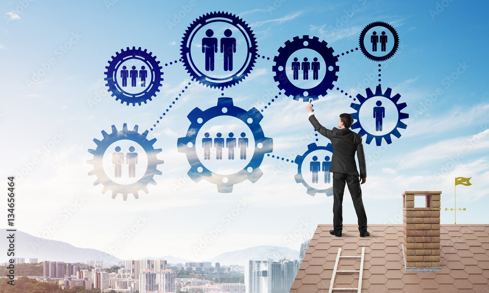 Businessman on house roof presenting teamwork and connection concept. Mixed media Businessman on house roof presenting teamwork and connection concept. Mixed media