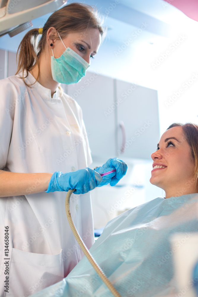 Female patient at the dentist. Female nurse preparing to put a suction