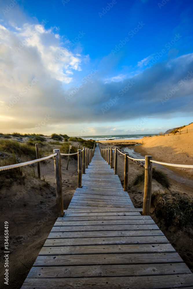 Wooden path to the beach on the dunes. Guincho beach in Cascais, Portugal Wooden path to the beach on the dunes. Guincho beach in Cascais, Portugal