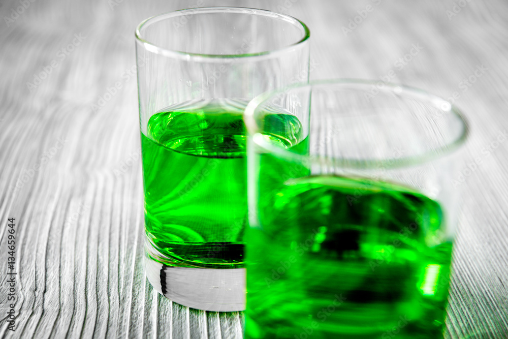 absinthe with sugar cubes and spoon on wooden background absinthe with sugar cubes and spoon on wooden background