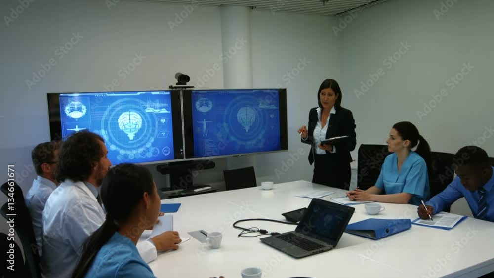 Doctor interacting with colleagues in meeting Doctor interacting with colleagues in meeting