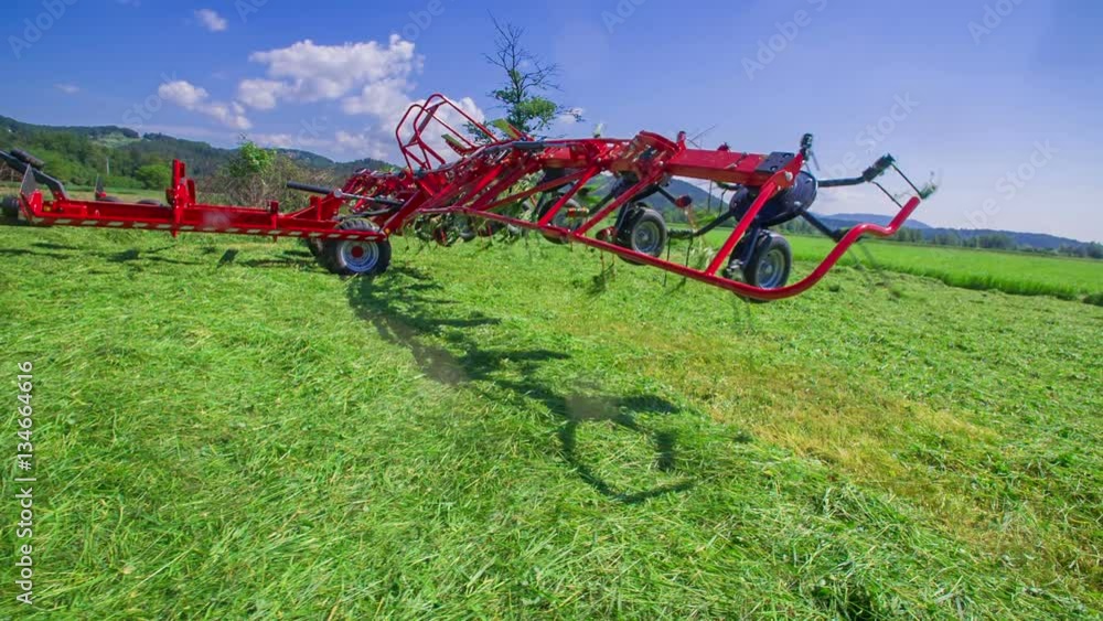 Rotary rakes are being lifted up in the air and are moving very fast. A ...