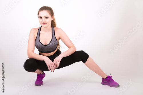 young fit girl stretching in workout clothes.
