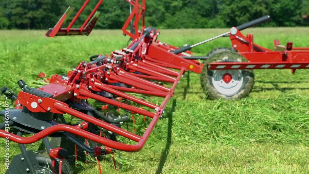 The mown grass is flying everywhere around. A farmer is driving a tractor and pulling a machine which is attached to it.
The mown grass is flying everywhere around. A farmer is driving a tractor and pulling a machine which is attached to it.