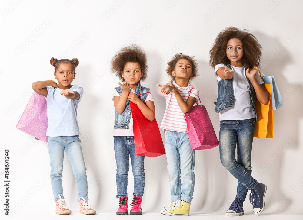 Four cute African girls with shopping bags on white background Four cute African girls with shopping bags on white background