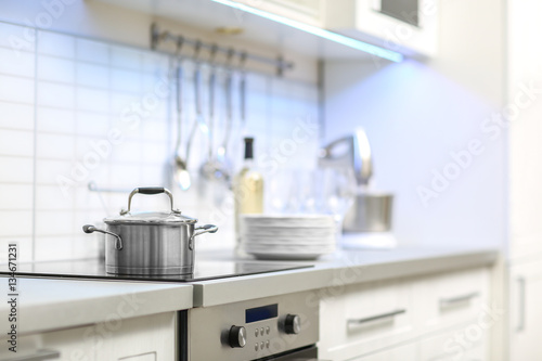 Metallic saucepan in modern kitchen interior