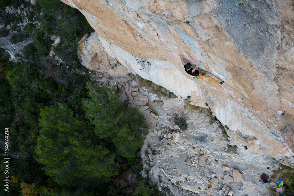 Rock climber, professional athlete, climbing in Siurana rocks, Spain. Extreme sports. 