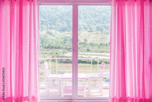 Look out window form living room with pink blinds