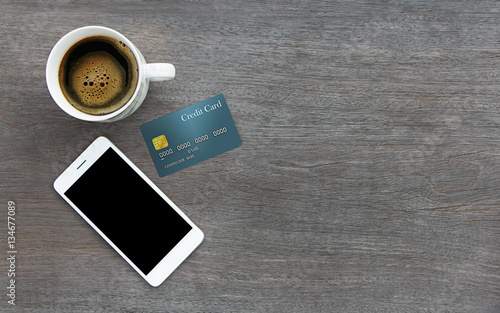 Mobile smart phone and credit card on wood texture background