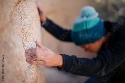 Φωτογραφία A young african american woman dressed for cold weather climbs on the shady side