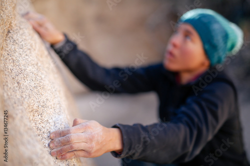 Billede på lærred A young african american woman dressed for cold weather climbs on the shady side