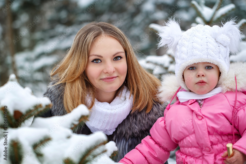 Mother holds daughter on hands outdoors frost. Family portrait. Family walk in a winter park. Family happiness. Mother holds daughter on hands outdoors frost. Family portrait. Family walk in a winter park. Family happiness.