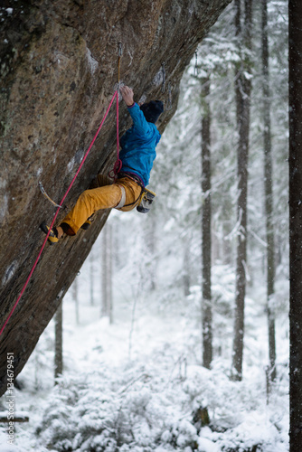 Rock climber on a challenging ascent. Extreme winter climbing.