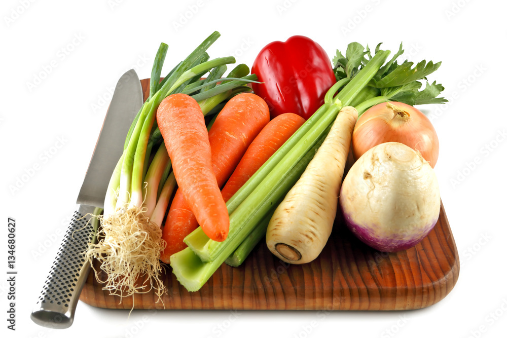 Vegetables on a chopping board with a knife ready for preparation Vegetables on a chopping board with a knife ready for preparation