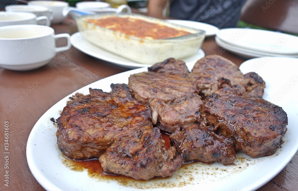 beef steak on plate at outdoor table.