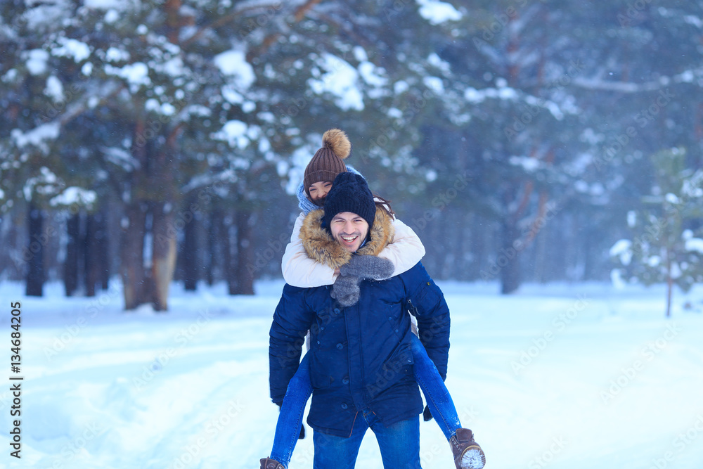 Fototapeta premium Playful couple walking outdoors in snowy woods