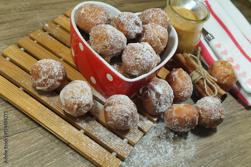 Sweet donuts in a dish in the shape of heart. Fat Thursday Slavic culture 

 photo