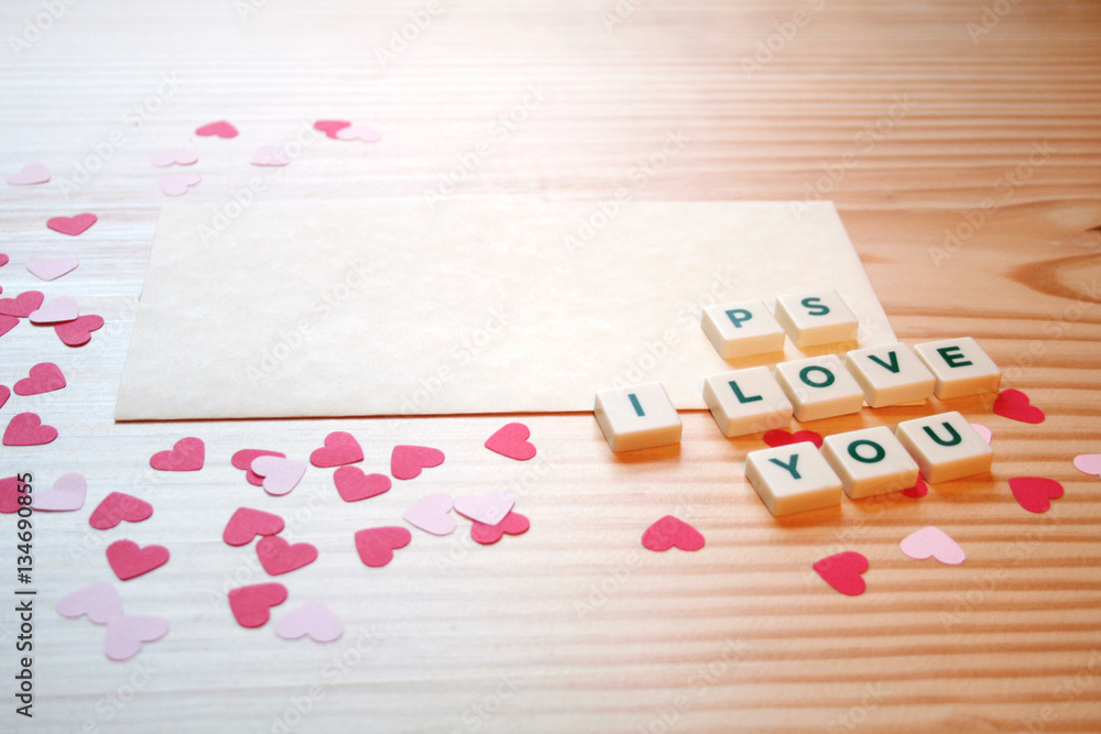 St Valentine's day: a love note for the loved one, with letters, pink and red hearts on a wooden table.