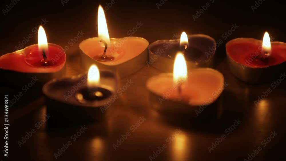 Candles in the shape of hearts are burning in the dark Candles in the shape of hearts are burning in the dark